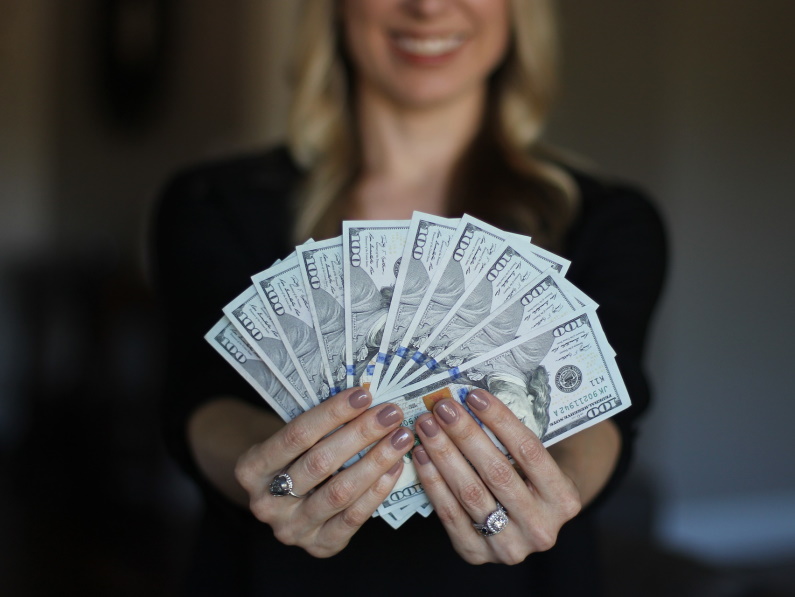 a woman smiling holding cash